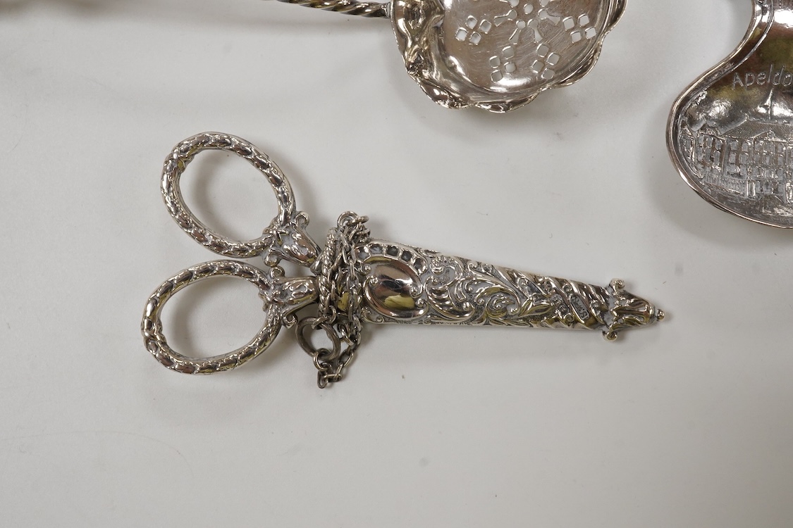 Small silver and white metal, including an Edwardian silver tea strainer, import marks for London, 1908, 15.7cm, a late Victorian silver sifter spoon, silver handled scissors with case, a white metal corkscrew and a whit